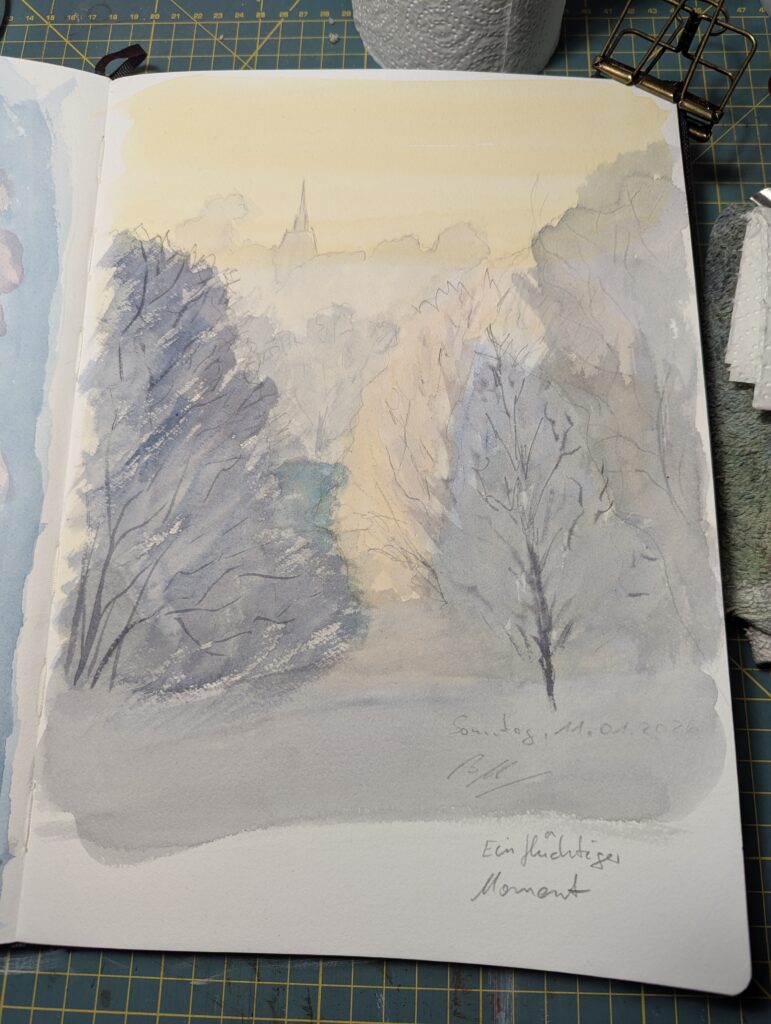 In einem aufgeschlagenen Skizzenbuch ist eine grobe Aquarellskizze zu sehen. Im Vordergrund stehen einige mit gefrostetem Nebel bedeckte Winterbäume. Dahinter sieht man in der Ferne von der tiefstehenden Sonne leicht beleuchtete weitere Bäume und einen Kirchturm, der herausragt. Die Lichtstimmung ist winterlich und kurz vor Sonnenuntergang mit gelblichen Tönen in der Sonne und blauen Tönen in den Schatten.